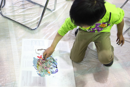 絵の具でマーブル模様のドローイングを描き、ガラス玉を転がして仕上げる Photo：Yukiko Koshima