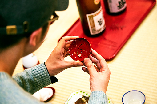 「新潟」をテーマにしたとんぼせんせいの朱器。日本酒を注ぐ酒器に原材料であるお米を描いたユニークなデザイン