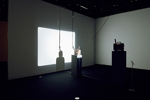 飯村隆彦『デッド・ムーヴィー』展示風景 / 未現像フィルムをループ投影する映写機に、別の映写機で光を投影し、その影だけを映し出す作品