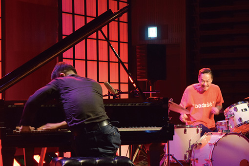 チトセピアホールで行われたドラマー・中村達也とピアニスト・スガダイローのデュオ「赤斬月」のセッション / ホールの客席部分にグランドピアノとドラムセットを置いた特設ステージでの演奏が行われた